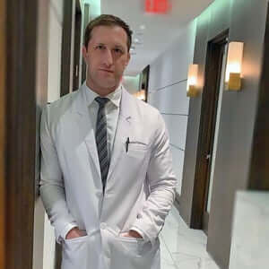 Doctor in a white coat standing in a clinic hallway